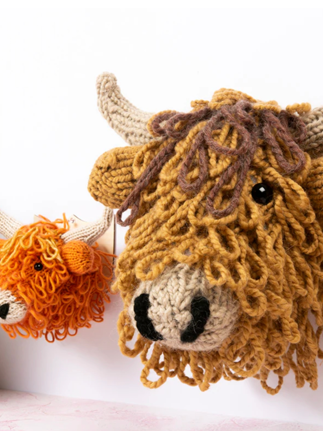 Highland Cow Head Knit Kit. A giant brown highland cow knit kit next to the small orange variant.