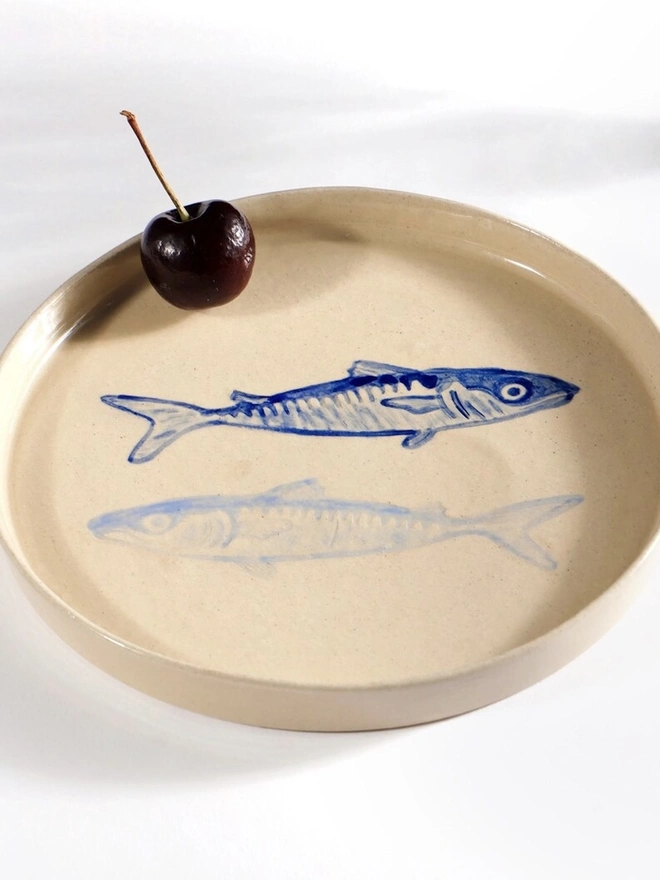 Handmade Ceramic Side Plate With 2 Blue Sardines Design, a white ceramic side plate sitting on a white table surface. 