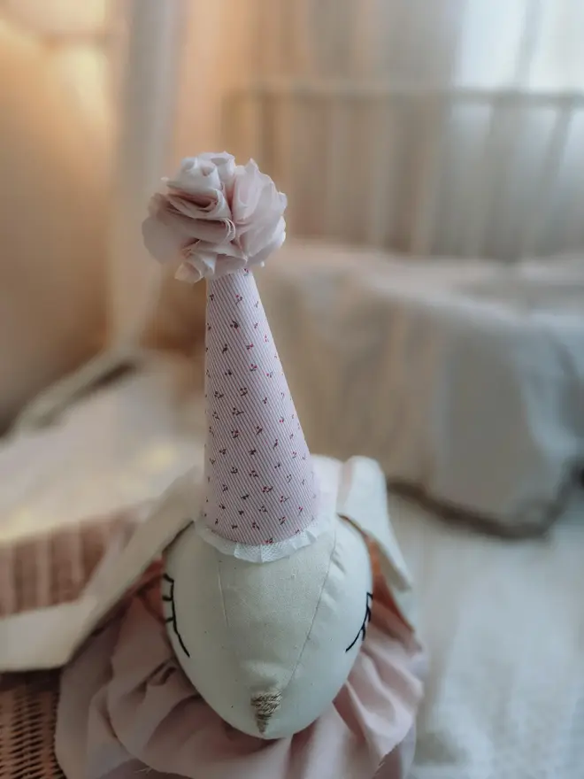 Rabbit Head Wall Mount, a cotton rabbit head wall decoration in a child's bedroom accompanied by other bedroom accessories. 