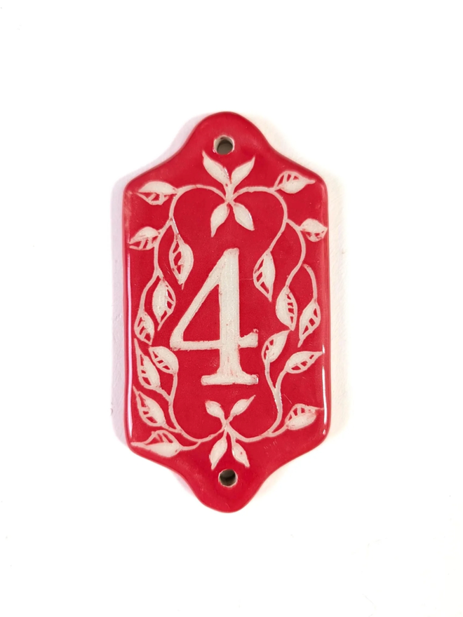 Red Sgraffito Leaf Address Tile. A tile with ‘4’.