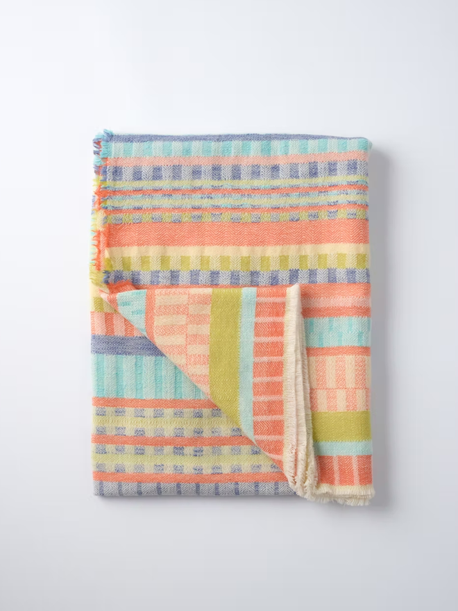 indie lambswool blanket. a multicoloured blanket photographed on a white background.