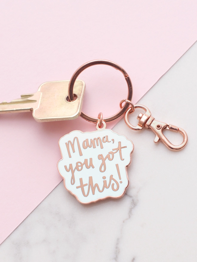 Mama you got this! enamel keyring laying on a pink and marble backdrop