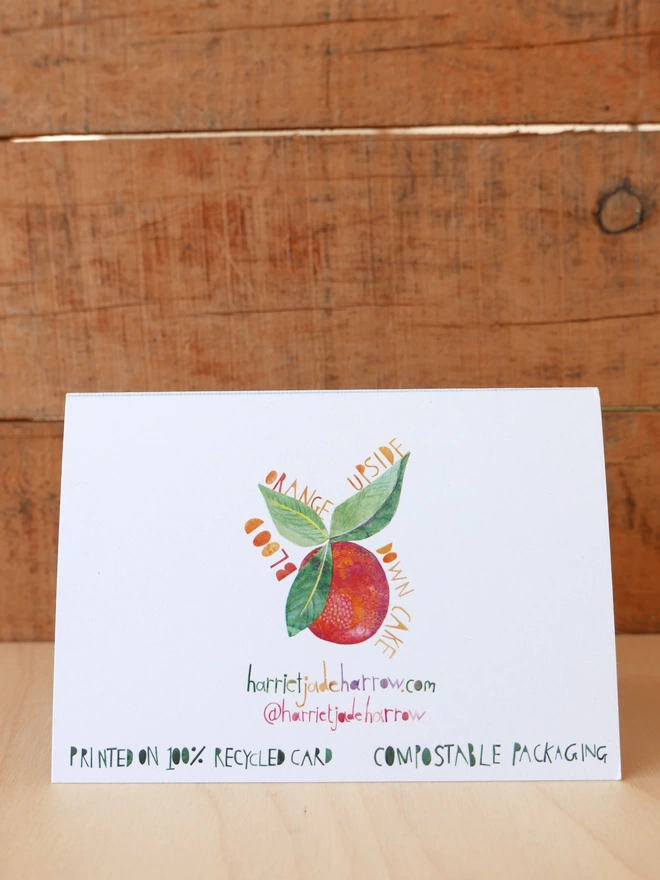The back of an Orange Upside Down Birthday Cake Card with an illustration of a blood orange & leaves
