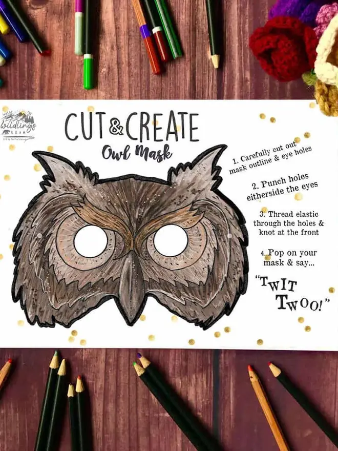 Cut And Create Forest Animals Children’s Masks Kit, an illustrated owl face, surrounded by coloured pencils on a dark wood background.