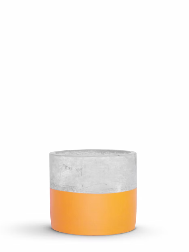 half full concrete plant pot. a grey concrete plant pot with the bottom half painted orange.