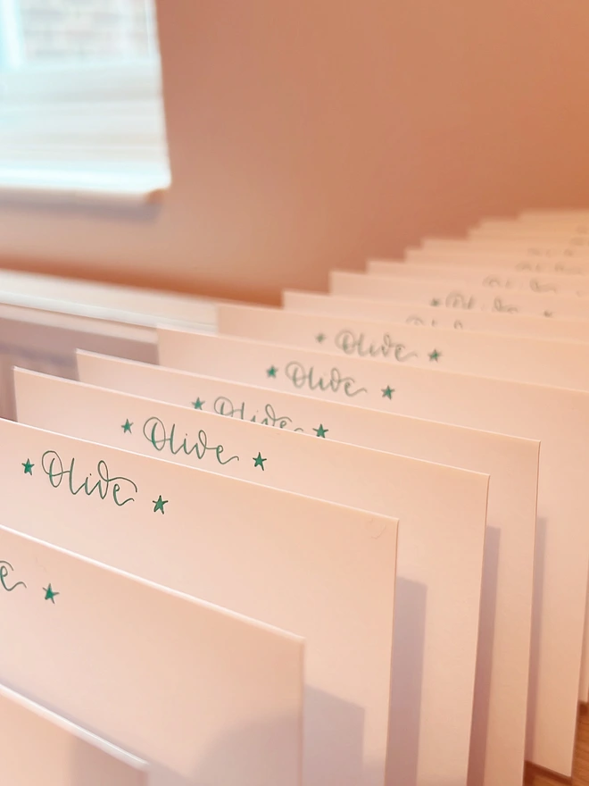 Notecards with Olive written in green calligraphy at the top of each card, with a star either side of the name