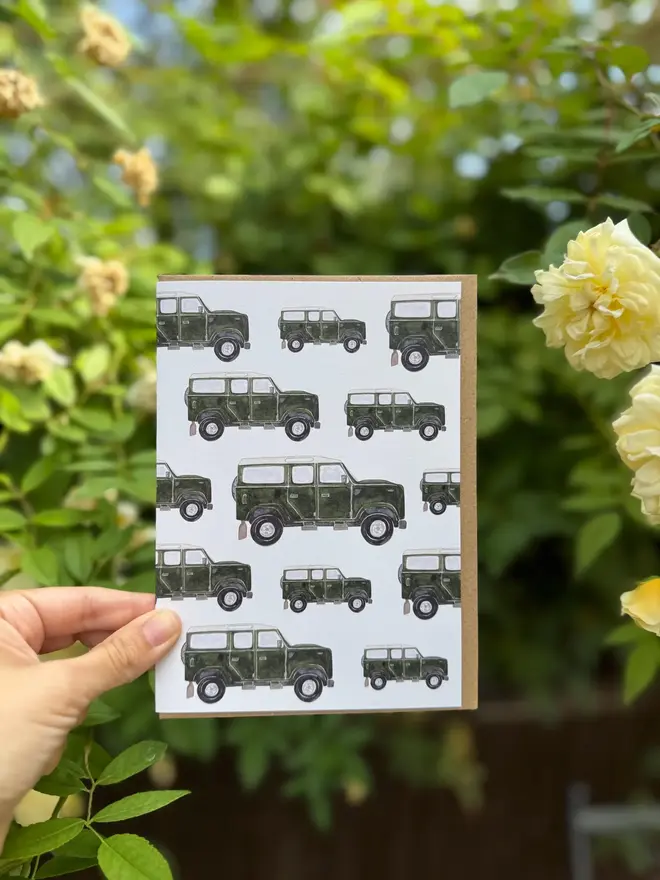 land rover defender illustrated card. card photographed against rosebush backdrop. 