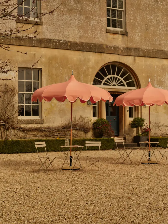 coral pagoda parasols in stone house courtyard