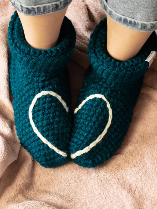 Teal crocheted socks with half a heart on each side
