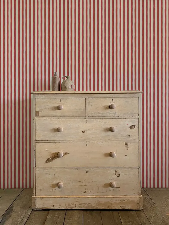 circus stripe painted wallpaper. red and white striped wallpaper on a wall.