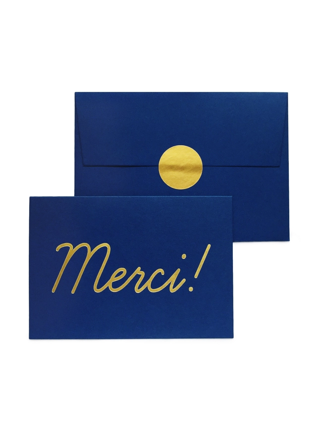 Luxury gold foil Merci thank you type on navy blue card with matching envelope and gold sticker label seal 
