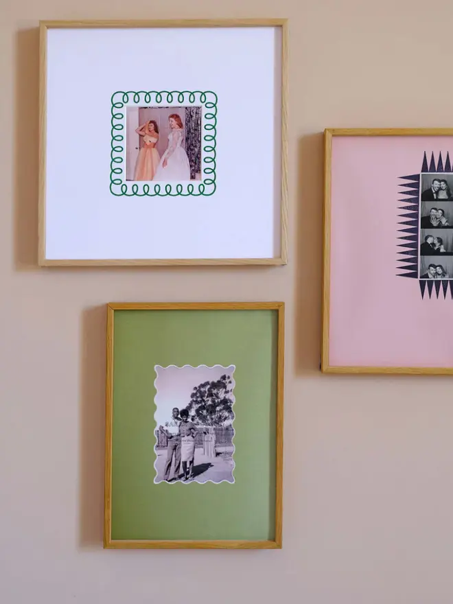 The chevron photobooth mount  frame with a pink mount featuring a decorative chevron border around a centered Instax photo, displayed on a neutral beige wall.