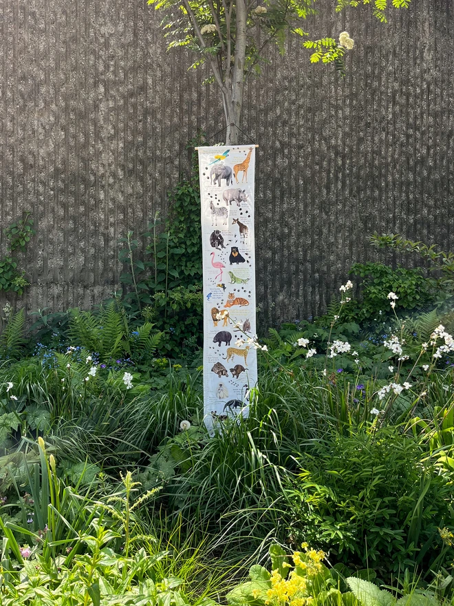 Fabric Height Chart with Illustrations of animals, hung on a tree