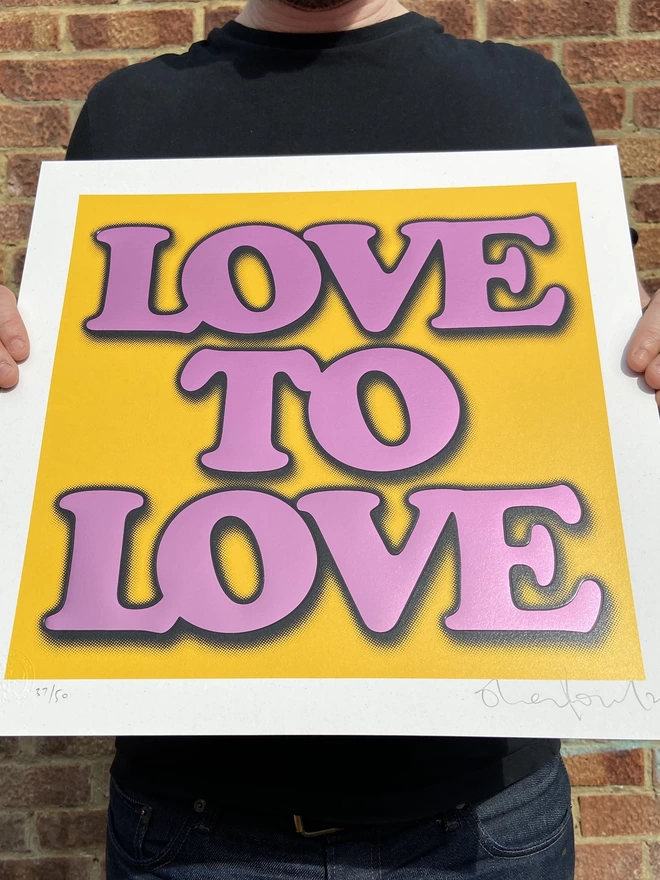Metallic Hot Foil  "Love to Love" Screen Print in yellow. typography says love to love with a drop shadow the print is square 