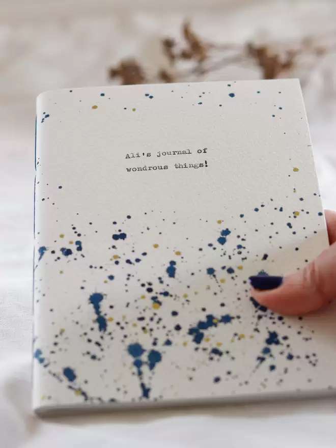 Close up of blue and gold splatter design, personalised notebook