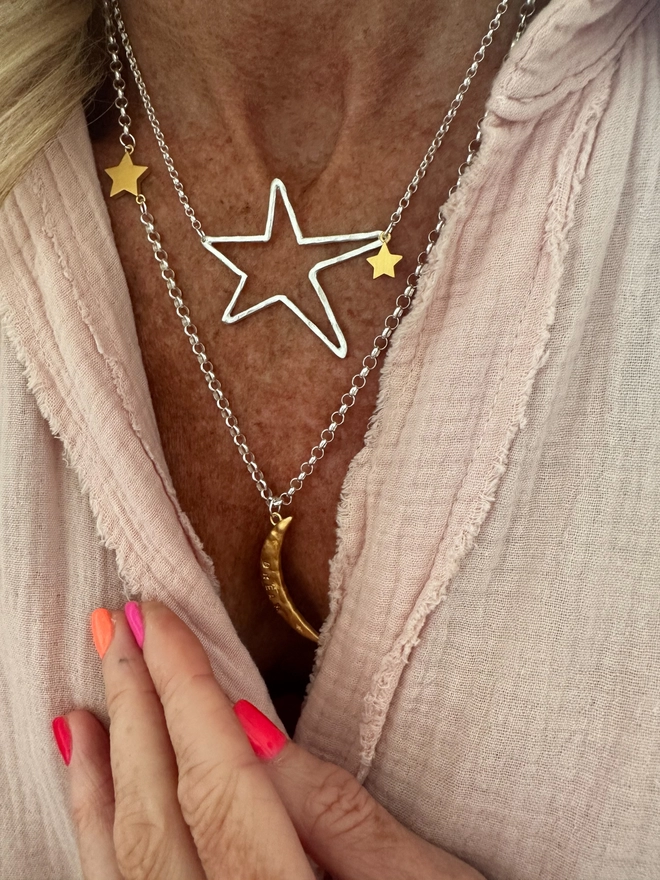 model wears a textured gold moon charm sits on a sterling silver heavy belcher chain, with linked gold cosmo star charm