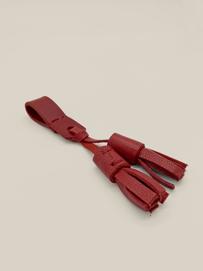pair of moccasin tassels in red leather