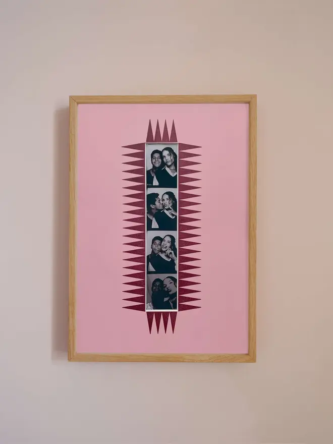 The chevron autofoto Strip Mount frame with a pink mount featuring a decorative frill border around a centered Instax Square photo, displayed on a neutral beige wall.