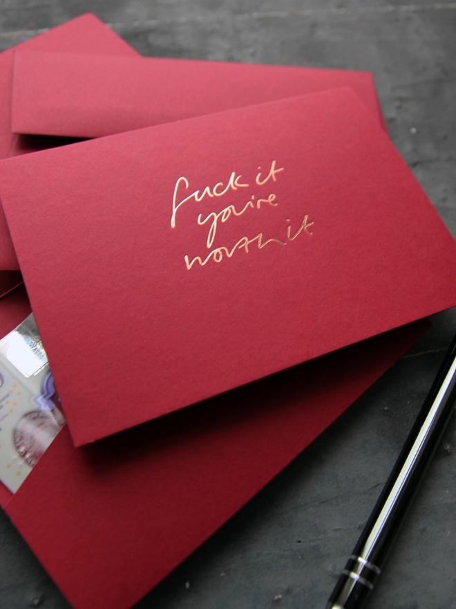 Fuck It You're Worth It cash card in scarlet with rose gold foil and matching envelope