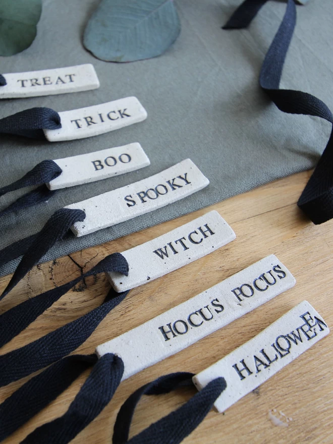 selection of ceramic tags in Halloween phrases, all tied with black ribbon