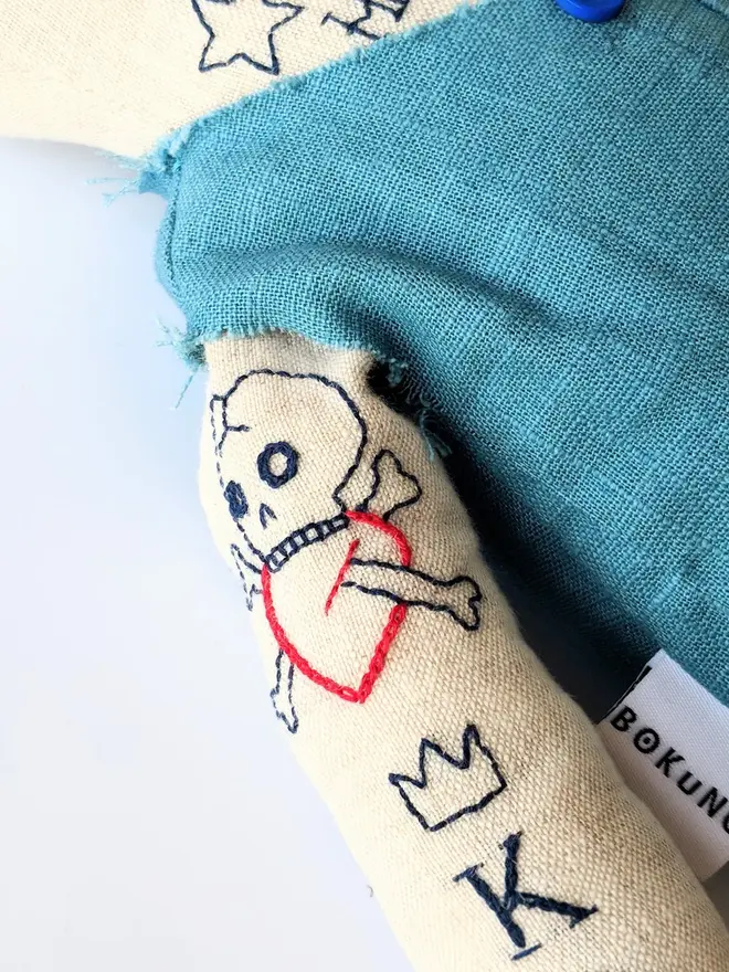 tattooed bear doll. a cream linen bear doll with embroidered arm tattoos and a blue waistcoat.