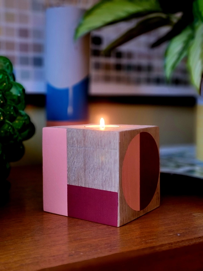 Wooden cube tealight holder on a shelf painted L and O in red and pink