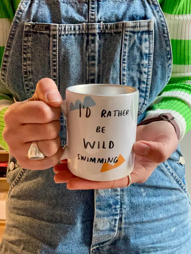 Mug reads 'I'd rather be wild swimming' with silver inner