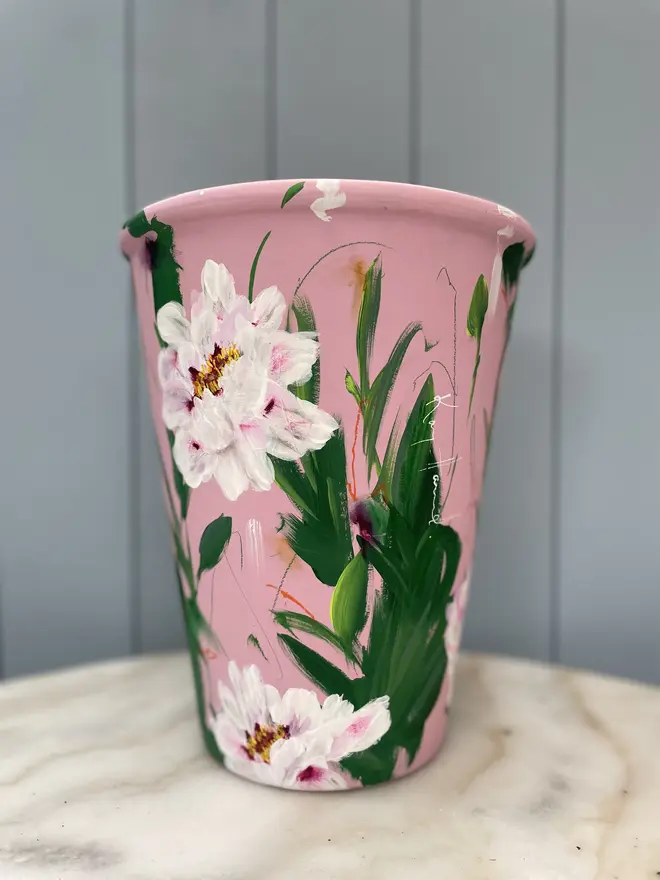 Unique hand-painted terracotta pot featuring pink tree peony on a pale pink background