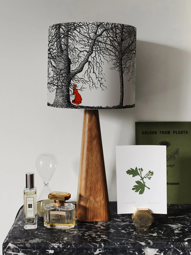 Handmade drum lampshade featuring a whimsical Little Red Riding Hood inspired design with a red cape, big bad wolf, and dark woodland scene.