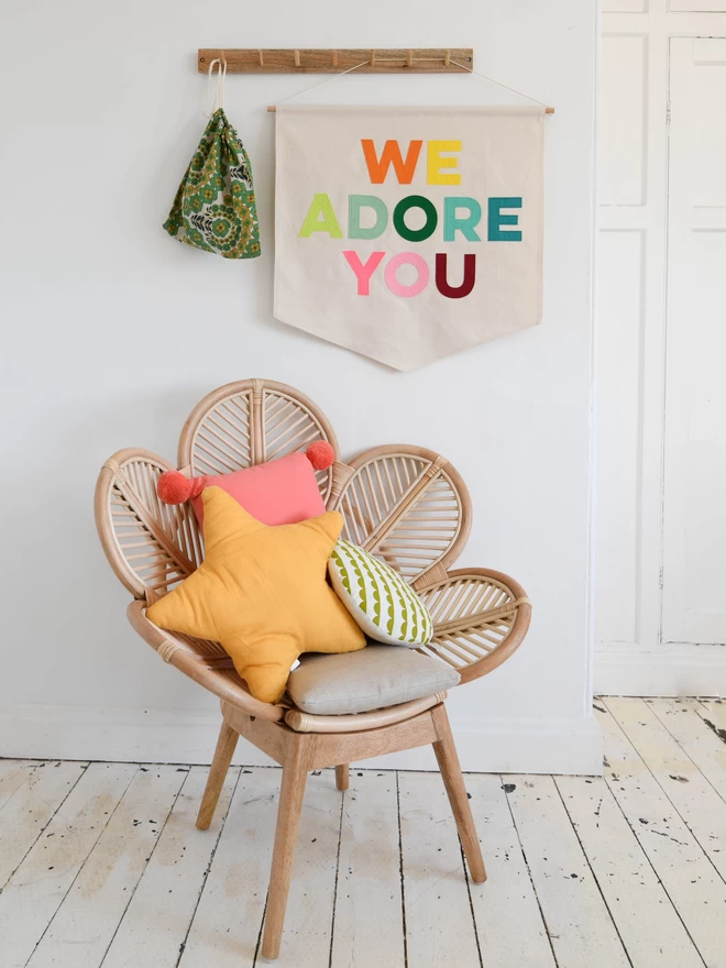 wall banner with the words we adore you sewn on in felt letters.