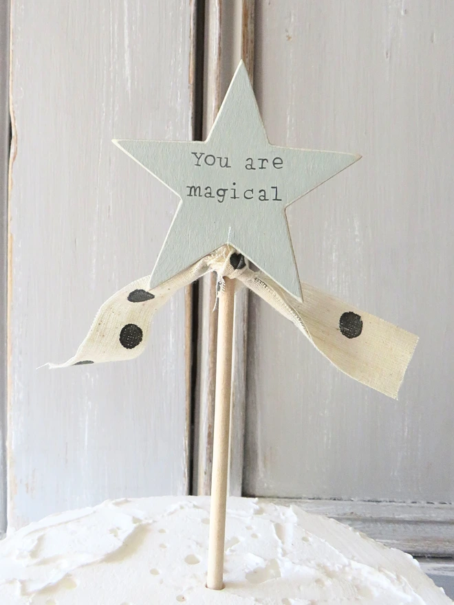 wooden star shaped cake topper with hand painted message and ribbon detail