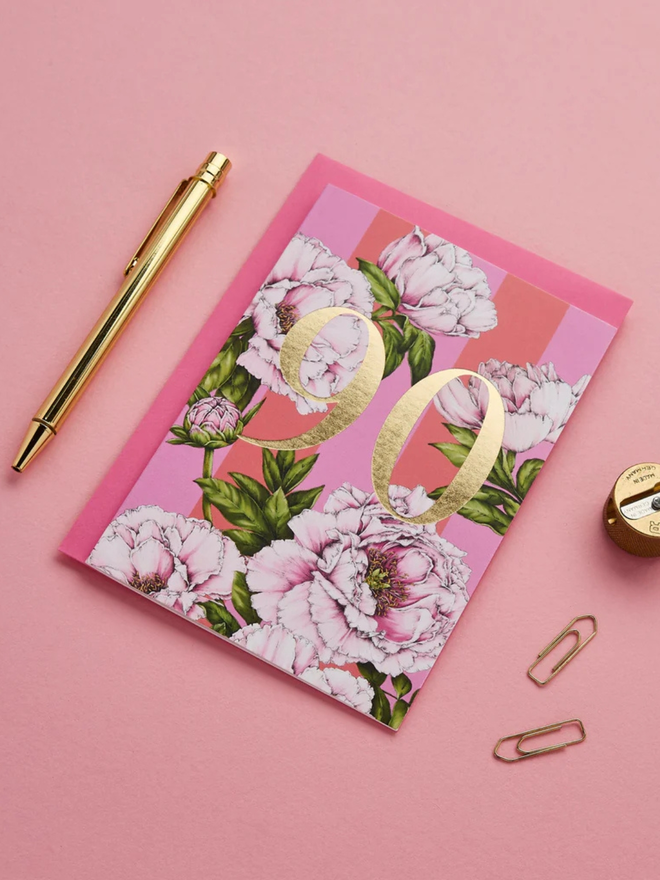 floral age milestone card. a pink floral 90th birthday card photographed against a pink background.