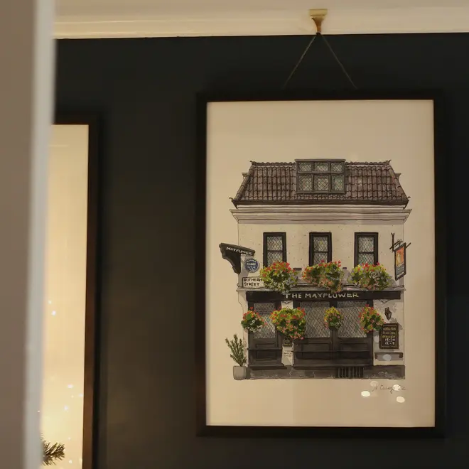 Rotherhithe The Mayflower Pub Giclée Print (Unframed), a print of a pub hanging on a black surface next to more framed prints. 