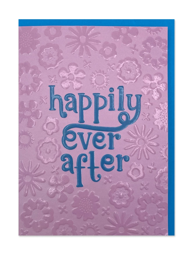 Wedding card with ’Happily Ever After’ message in blue chunky 70’s inspired hand lettering on a complementing pink psychedelic embossed floral pattern  
