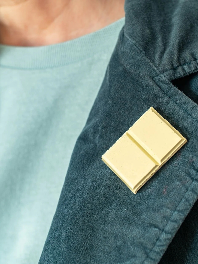 chocolate pin badges. a white chocolate badge on a coat lapel.