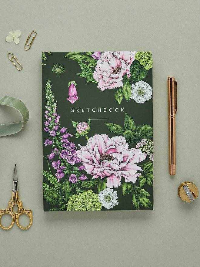 'Summer Garden' A5 Hardback Sketchbook. a green floral sketchbook photographed on a plain grey background.