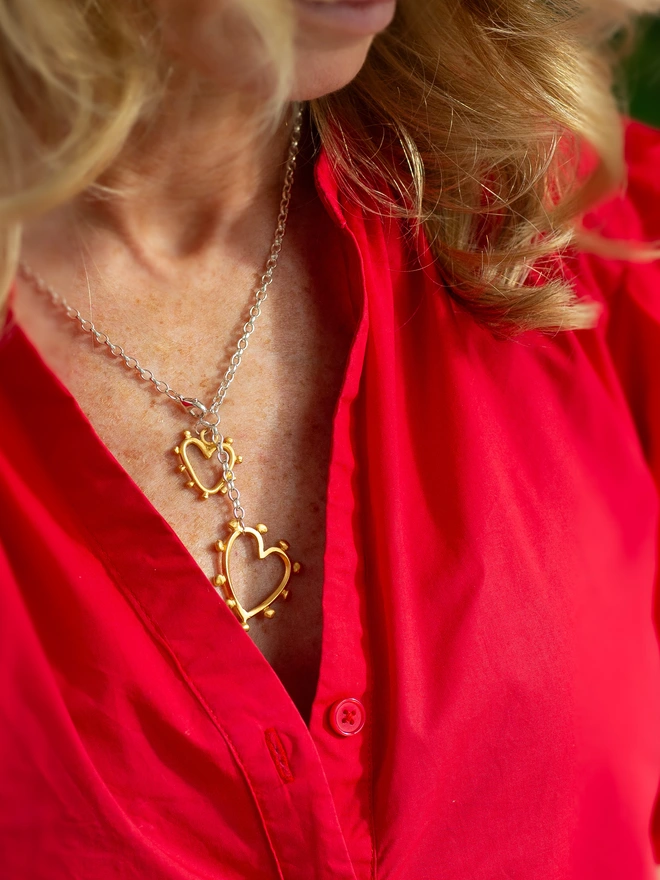 Make it your signature. The Belong Together Lariat Necklace pairs a sleek Y-shaped silhouette with two mixed metal studded hearts for a striking yet wearable finish. Designed to move with you, this statement heart necklace brings modern romance and effortless style to everyday looks.