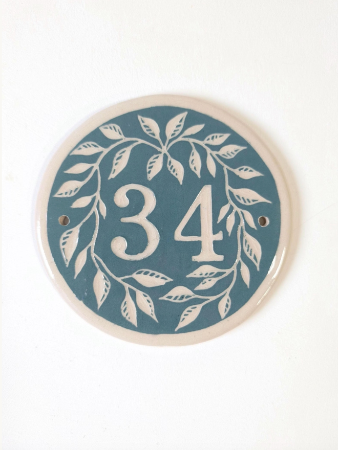 Custom Round Ceramic House Number with Leaves. A house number in pine green.