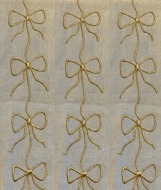 Hand Painted Bow Print Sustainable Linen Table Runner, a table runner with a metallic gold bow design. 