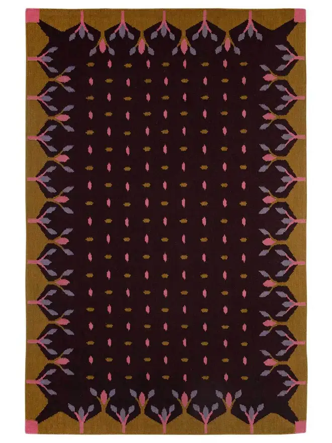 Hedgerow Flatweave Rug, a colourful rug sitting on a plain backdrop. 