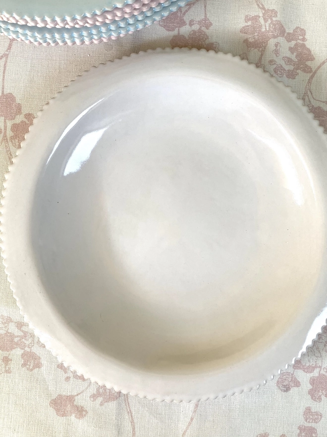 top view of white pasta bowl with scalloped edg