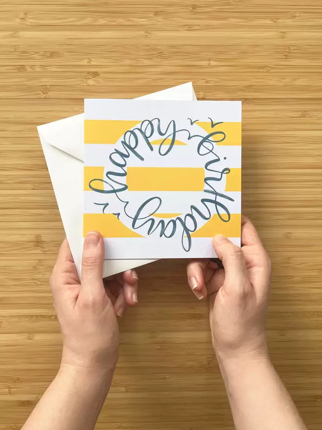 Ship-shape 'Happy Birthday' Card in yellow and white seen held by two hands.