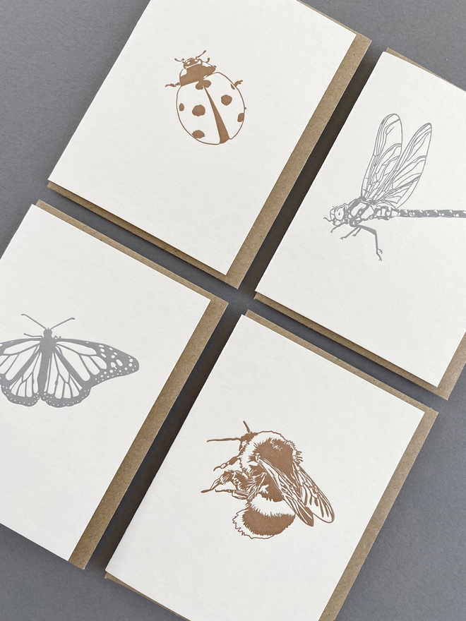 Close up of the metallic insect designs on small cards with envelopes