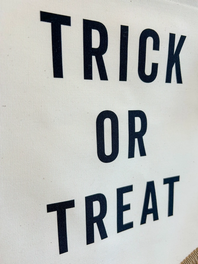 Trick or treat printed fabric Halloween banner. Black text on fabric