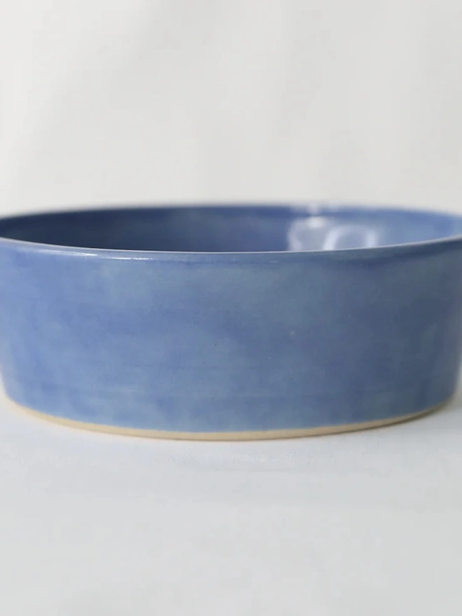 Classic Pasta Bowl, a colourful ceramic bowl sitting on a plain surface against a grey backdrop. 