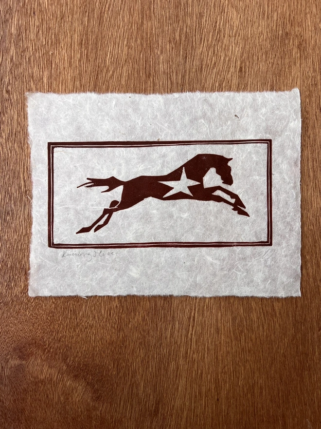 Hand-pulled running horse lino print on natural handmade paper, featuring a bold graphic illustration of a horse in motion.