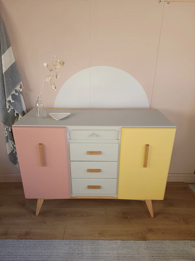 Pastel painted mid-century sideboard with greige top and drawers, pink and yellow doors