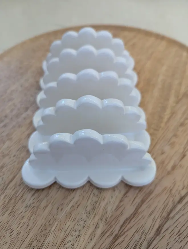 scalloped stoneware toast rack. a white rack for toast with scalloped edges.