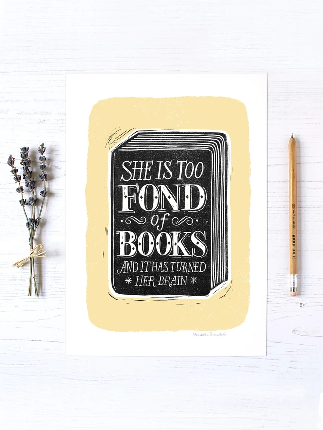 she is too fond of books black and yellow print unframed with lavender and wooden pencil