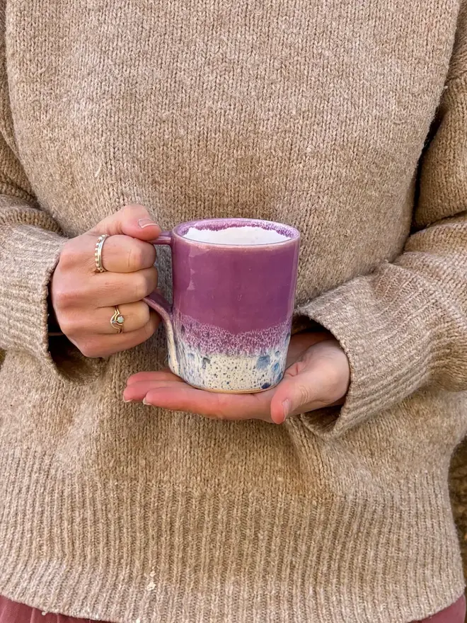 Shoreline Standard Mug, a colourful mug held in front of a person in a jumper. 